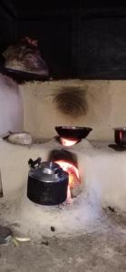 un forno in pietra con pentola e fuoco di Daragaon Retreat (Gurung Homestay) a Pelling