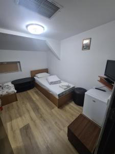 クラヨーヴァにあるHotel Safta Residenceのベッド1台とテレビが備わる小さな客室です。