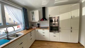 a kitchen with white cabinets and a sink and a window at Steppacher Ferienappartements in Friedenweiler +42 photos