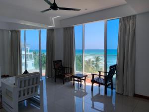 a living room with a view of the ocean at Nilaveli Beach Apartment Sri Lanka in Nilaveli