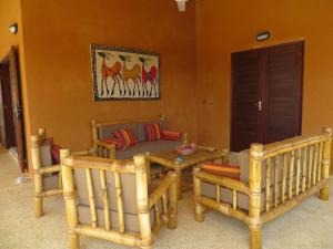 a living room with a couch and a table and chairs at Villa Rebecca in Nianing