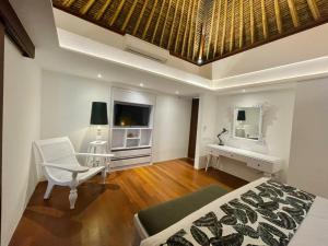 a bedroom with a bed and a desk and a mirror at Calm Villa in Seminyak