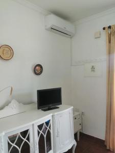 un monitor de ordenador sentado en la parte superior de un escritorio blanco en Casas da Saibreira - nº9 en Elvas