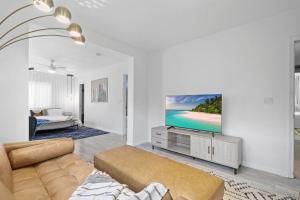 un salon avec un canapé et une télévision à écran plat dans l'établissement Mid-Century Stunner // Large Yard and Patio for Indoor/Outdoor Living, à Phoenix