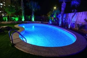 a swimming pool with lights in a yard at night at Villa Yotam 4BR Heated pool וילה יותם 4 חדרי שינה בריכה מחוממת in Eilat