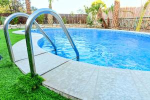 a swimming pool with a ramp leading into the water at Villa Yotam 4BR Heated pool וילה יותם 4 חדרי שינה בריכה מחוממת in Eilat