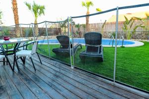 a deck with a table and chairs and a pool at Villa Yotam 4BR Heated pool וילה יותם 4 חדרי שינה בריכה מחוממת in Eilat +25 photos