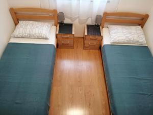 two beds in a small room with wooden floors at Apartment Loder in Vir