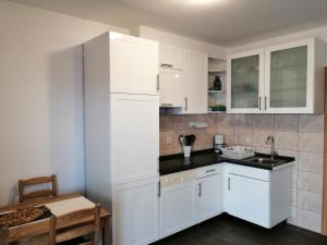 a white kitchen with white cabinets and a table at Apartment Loder in Vir