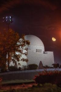 un gran edificio blanco con una luna en el cielo en Hotel 7 DHA en Karachi