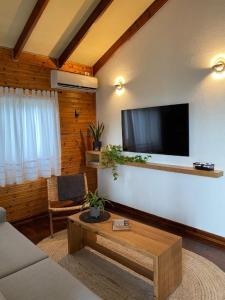 a living room with a flat screen tv on a wall at Bikta Bakfar Ramot in Moshav Ramot