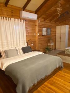 ein Schlafzimmer mit einem großen Bett in einer Hütte in der Unterkunft Bikta Bakfar Ramot in Moshav Ramot