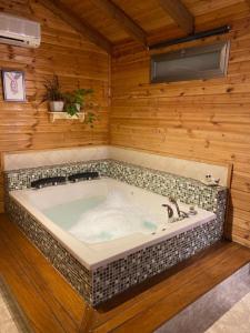 eine Whirlpool-Badewanne in einem Zimmer mit Holzwänden in der Unterkunft Bikta Bakfar Ramot in Moshav Ramot