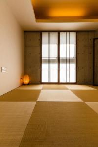 Habitación vacía con ventana grande y suelo de baldosa. en Kouri beach side villa YUMANDI, en Nakijin