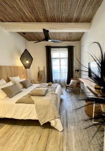 een slaapkamer met een groot bed en een houten plafond bij Le S in Argelès-sur-Mer
