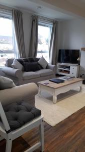 a living room with a couch and a coffee table at The Dookit - Aviemore Town House in Aviemore