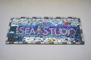 un signo de mosaico en una pared con las palabras "buena tienda" en 302 On Old Sea View Road Chelsea, en Port Elizabeth