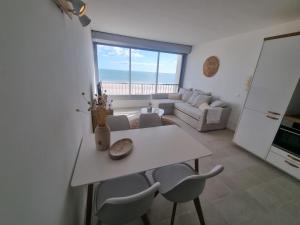 uma sala de estar com uma mesa branca e cadeiras em Superbe Studio Rénové les pieds dans l'eau! em Marseillan