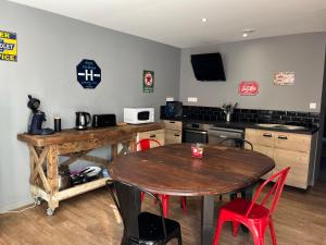 cocina con mesa de madera y sillas rojas en Maison de pêcheur à 10 minutes de la plage à pieds, en Cayeux-sur-Mer