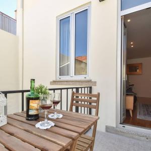 einen Holztisch mit zwei Gläsern Wein auf dem Balkon in der Unterkunft Oporto Lovely House in Porto