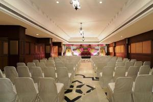 duży pokój z białymi krzesłami i sceną w obiekcie Radha Regent, Chennai w mieście Ćennaj