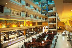 a restaurant with tables and chairs in a building at Radha Regent, Chennai in Chennai