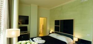 a bedroom with a bed and a lamp and a television at Le Notti in Villa in Fontanellato