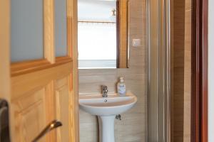 a bathroom with a white sink and a window at Family Homes - Dom Wakacyjny EDA in Władysławowo