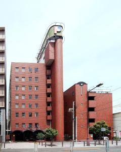 een hoog rood bakstenen gebouw met een gebouw bij Hotel Sun Plaza Sakai in Sakai