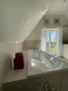 a white bath tub in a room with a window at Villa Cassandre in Esvres