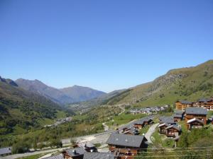 Blick auf ein Tal mit Häusern und Bergen in der Unterkunft Les Menuires skis aux pieds in Les Menuires