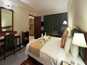Un pat sau paturi într-o cameră la Radha Regent, Chennai