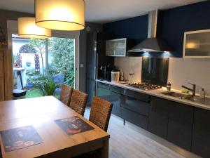a kitchen with a wooden table and a counter top at Agréable maison de ville ,calme avec tous les commerces à 150M in Cherbourg en Cotentin