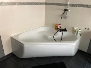 a white bath tub in a bathroom with a shower at Agréable maison de ville ,calme avec tous les commerces à 150M in Cherbourg en Cotentin +10 photos