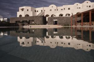 a building with its reflection in a body of water at Orama Hotel & Spa in Fira