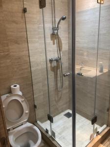 a shower stall with a toilet in a bathroom at Au Rez de jardin, Bel appt au sein du golf Montgomery in Marrakesh