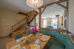 een eetkamer met een tafel en een trap bij Haus Engel in Burg-Reuland