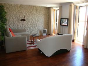 a living room with two white chairs and a couch at Simply Bairro Alto in Lisbon