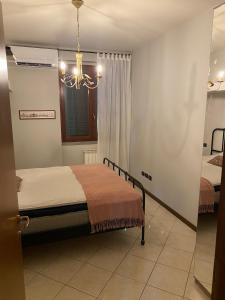 a bedroom with a bed and a chandelier at Casa Panzano Tuscany in Panzano