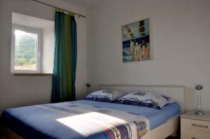 a bedroom with a blue bed with a window at Apartments Adriana in Bol