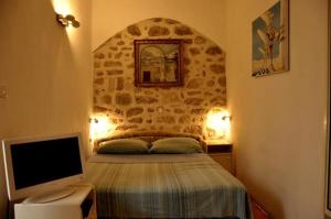 a bedroom with a bed with a stone wall at Apartments Adriana in Bol