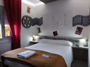 um quarto com uma cama e alguns desenhos na parede em La Casona de Betanzos em Betanzos