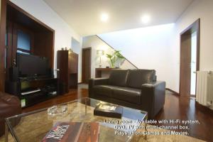 a living room with a leather couch and a television at 2Stay - Luxury in Ponta Delgada
