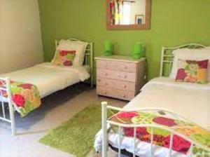 a green room with two beds and a dresser at Gites la Charrue in Monsec