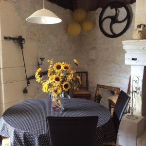 a vase of sunflowers on a table in a room at Gites la Charrue in Monsec +7 photos