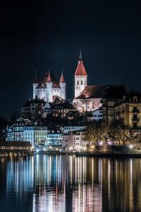 Blick auf eine Stadt mit Schloss in der Nacht in der Unterkunft Chez Muna & Lucien in Thun