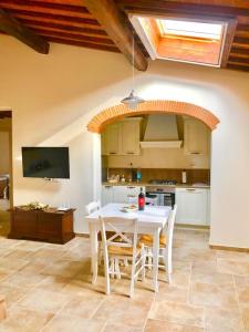 a kitchen with a white table and chairs in a room at Laura Chianti Vacanze in Poggibonsi