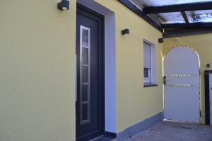 uma porta ao lado de um edifício amarelo com um arco em Apartment mit Terrasse und eigenem Eingang em Radevormwald