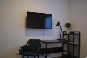a room with a desk and a television on a wall at Apartment mit Terrasse und eigenem Eingang in Radevormwald