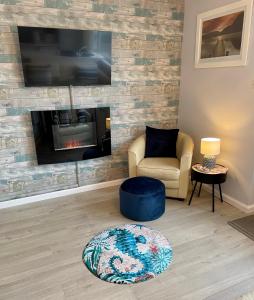 a living room with a fireplace and a chair at Apartment 18 Hill View in Brean